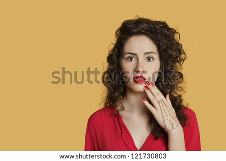 Portrait of a shocked woman over colored background