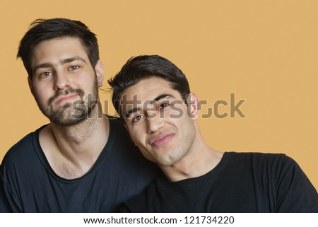 Portrait of young male friends over colored background