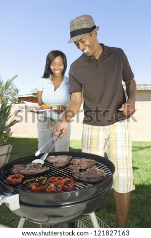 Happy African American couple cooking together in lawn