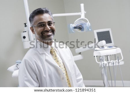 Portrait of a confident indian male dentist in clinic