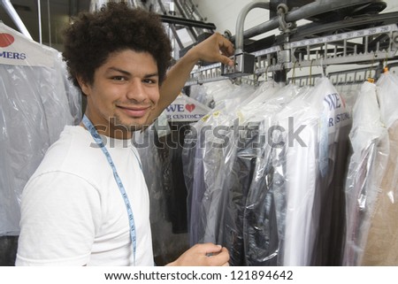Portrait of a young mixed race man working in dry cleaning store