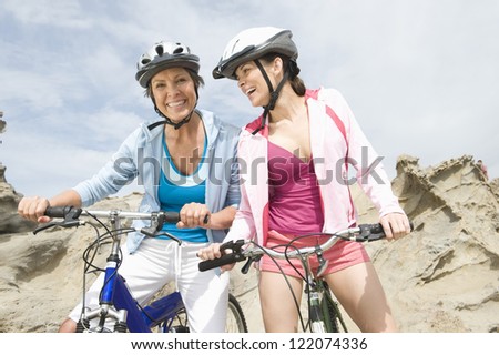 Portrait of a happy mother with daughter riding bicycle