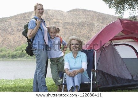 portrait of a happy female Caucasian family on vacations with campaign tent in the background
