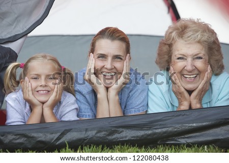 Portrait of happy Caucasian female family lying inside tent on vacations