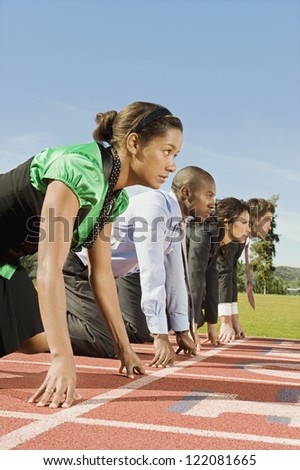 Side view of multi ethnic business people at starting line on race track