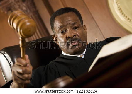 African American judge pounding mallet in courtroom