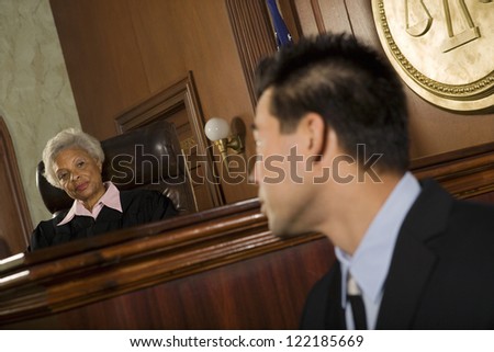 Judge and lawyer looking at each other in courtroom