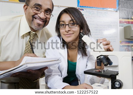 Portrait of professor and female student with microscope