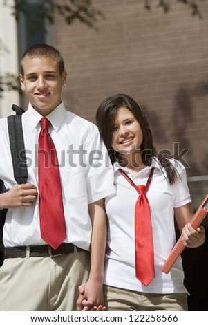 Happy young couple standing together in college campus