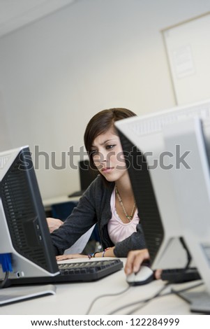 Young female student working on computer in lab