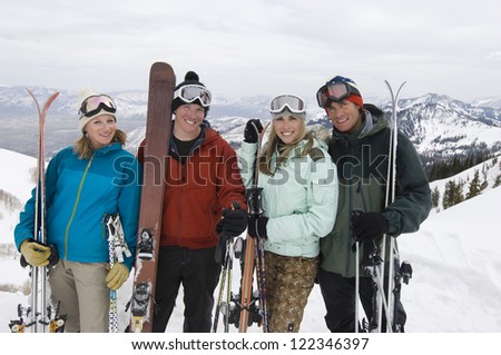 Portrait of skier friends standing in mountains