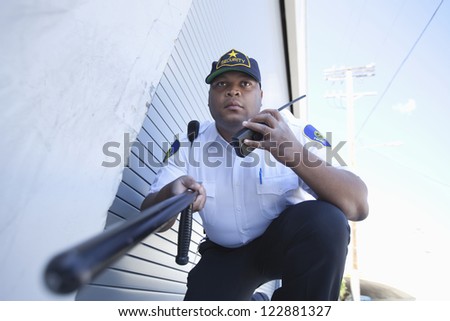 Low angle view of security guard holding a baton