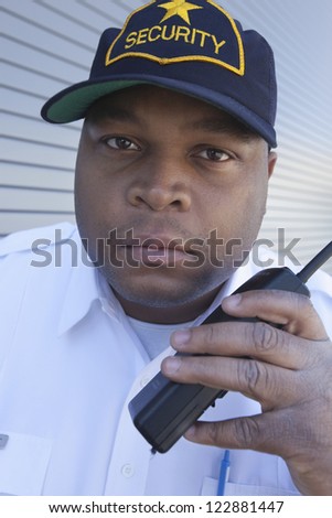 Closeup of security guard using walkie talkie