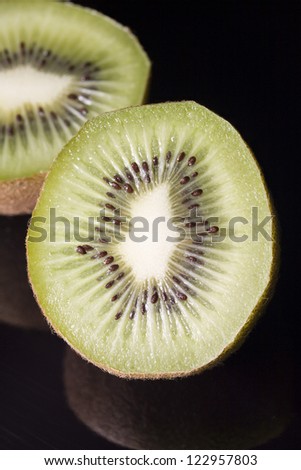 Fresh kiwi fruit slices isolated over black background