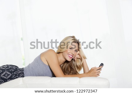 Young woman with cell phone lying (Soft focus)