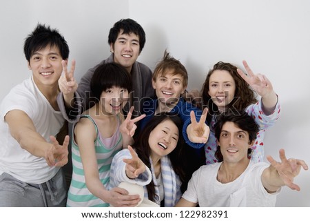 Group portrait of young friends showing peace sign