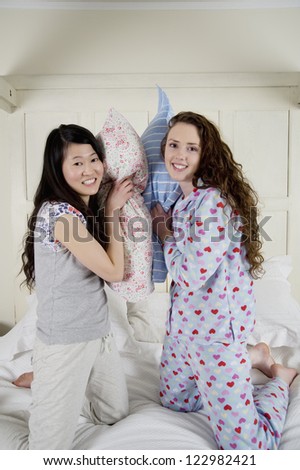 Happy female friends having pillow fight