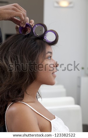 Side profile of young woman wearing curlers