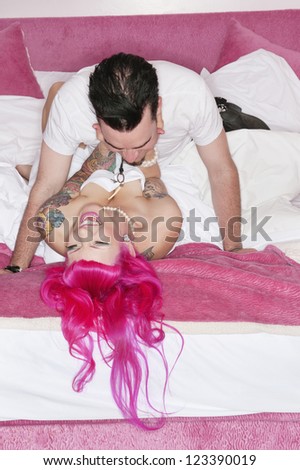 Man lying on top of young woman on bed