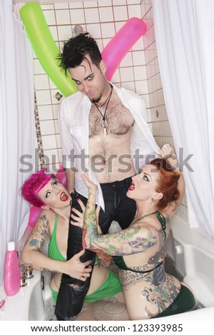 Man standing in bathtub with women seducing him