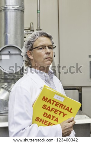 Middle-aged man holding data sheets of factory