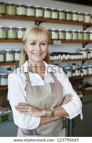 Portrait of a happy senior employee with arms crossed in spice store