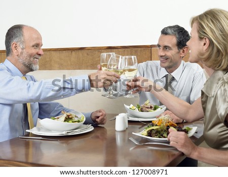 Caucasian business colleagues toasting wine together