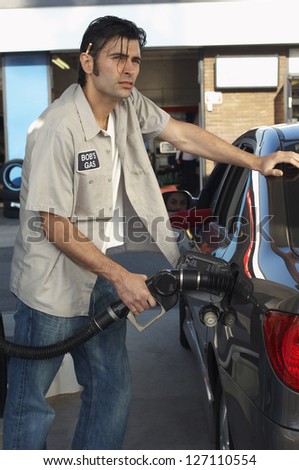 Gas station worker refueling car at petrol station