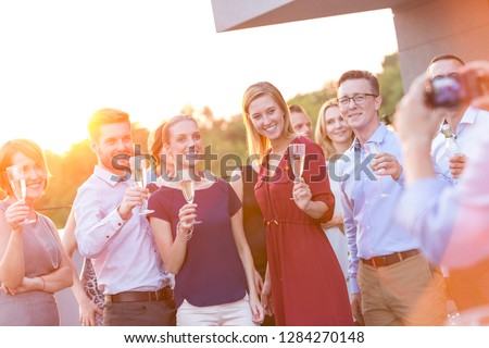 Young business colleagues talking while standing at rooftop during party