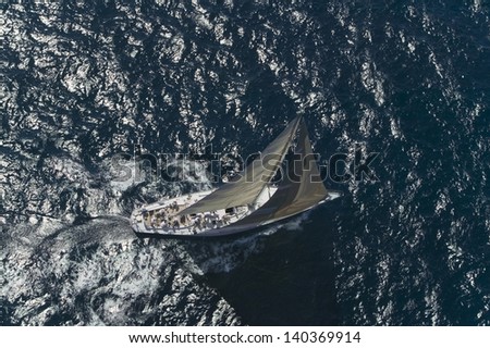 Top view of a sailboat in the blue ocean