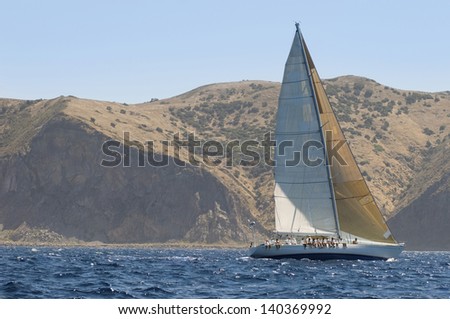Side view of a sailboat near the coast in an ocean