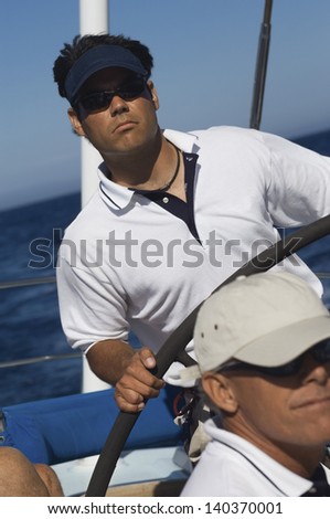 Young man at the helm of a sailboat In the ocean