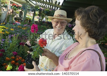 Happy senior couple shopping for flowers at the plant nursery