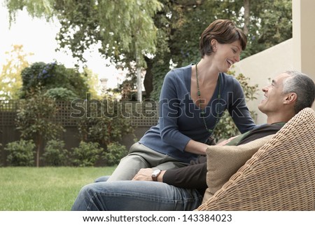 Happy loving woman sitting on man\'s lap in lawn