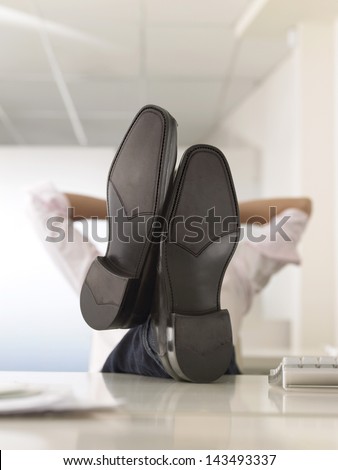 Businessman reclining with his feet up on desk in office