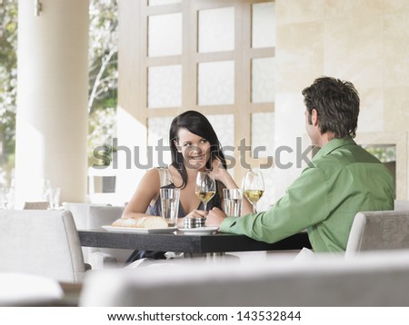 Happy young couple sharing wine at outdoor restaurant