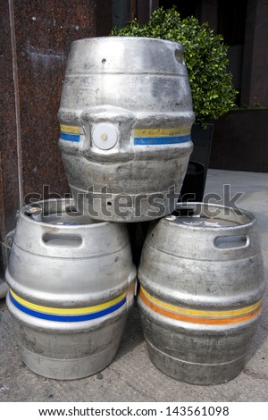Three empty metal kegs outside a bar
