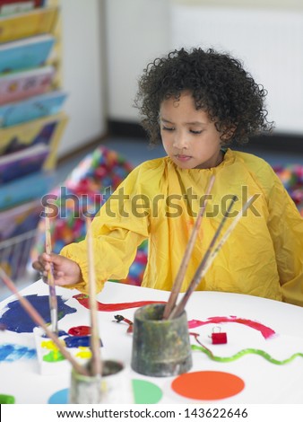 Cute little girl painting in art class