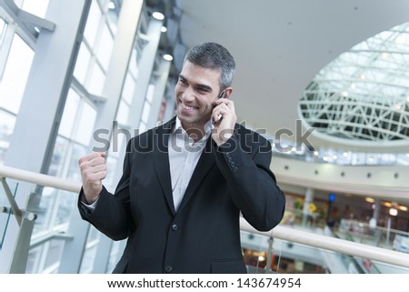 Businessman celebrates talking on mobile phone