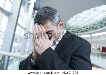 Disappointed businessman with head in hands