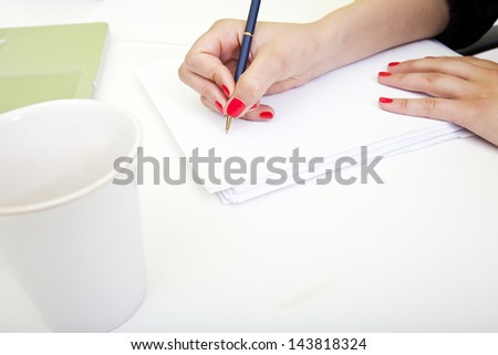 Close up of woman\'s hands writing on paper.