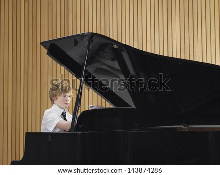 Teenage boy playing piano in music class