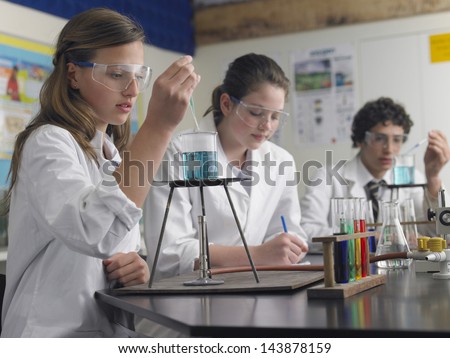 Teenage Students Caring Out Experiments In Chemistry Class