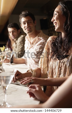 Young multiethnic group at the bar with cocktail glasses Young multiethnic group at the bar with cocktail glasses