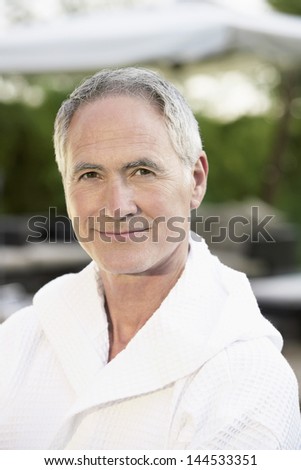 Portrait of happy middle aged man in bathrobe outdoors