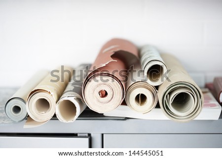 Rolls of wallpaper on desk
