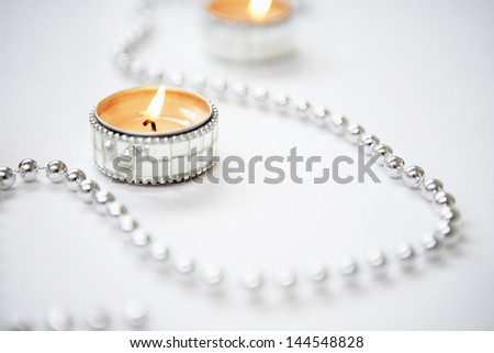 Closeup of lit tealight candles and silver garland