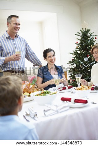 Happy family at dinner table enjoying food on Christmas