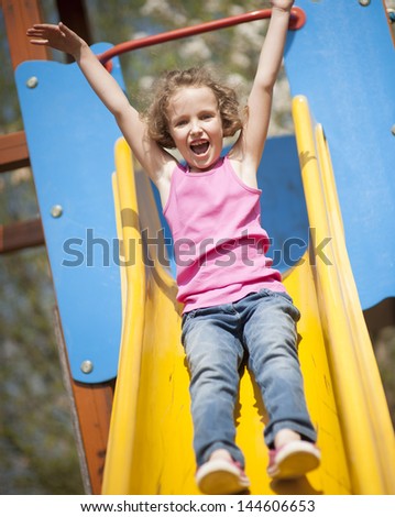 Close-up view of young girl on slide in playground