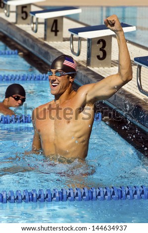 Young male swimmer celebrating victory in the swimming pool